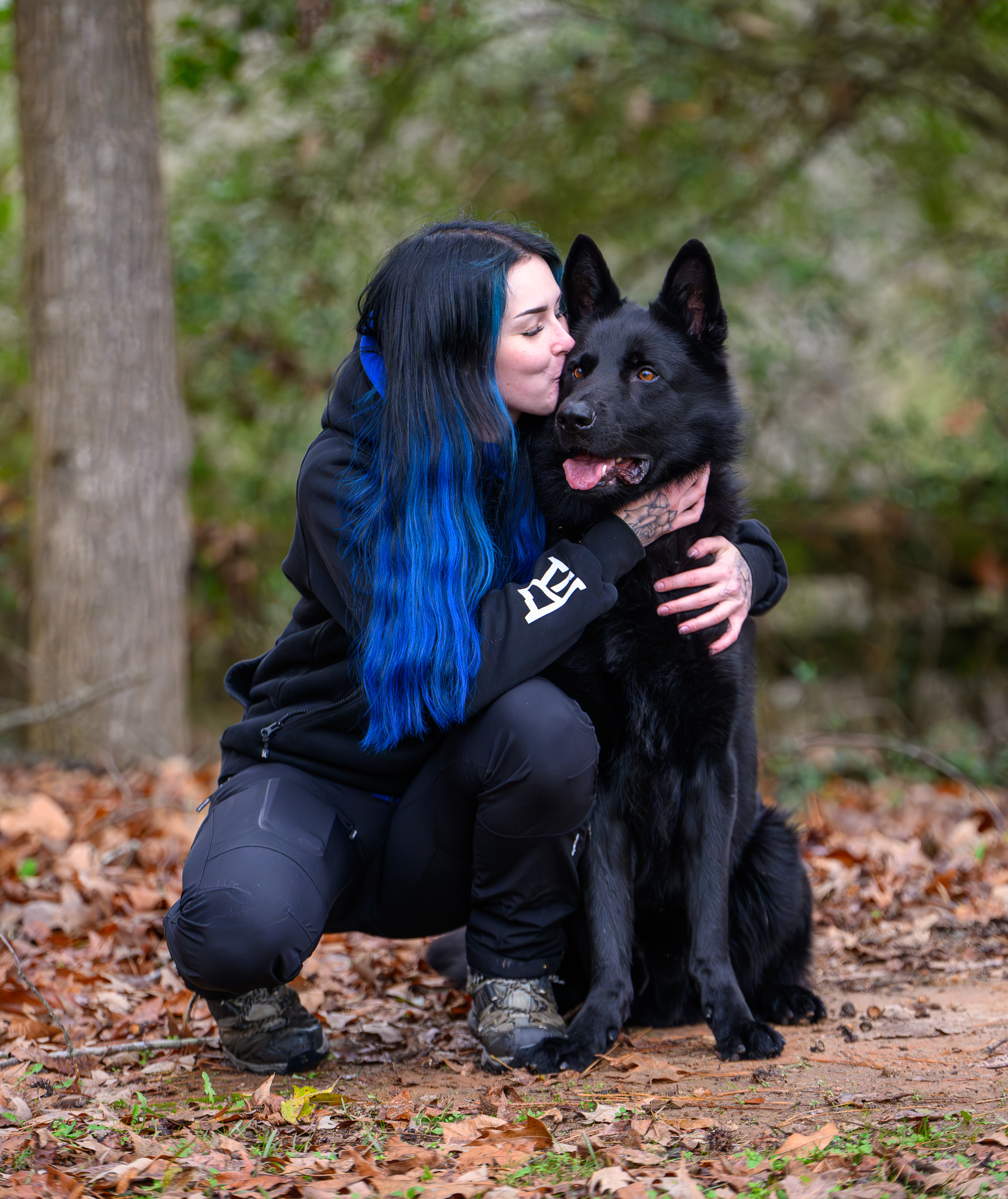 Jenna Tihumäki kissing her black German Shepherd