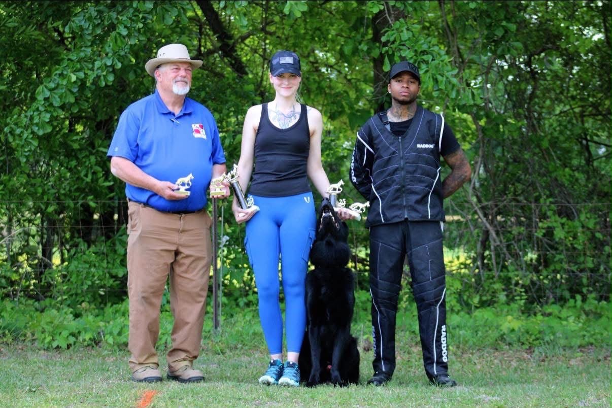 Jenna and Damon with a judge and their dog at a trial